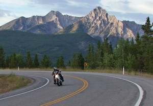 Motorcycle on a highway under a mountain.