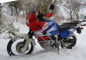 Motorcycle parked in the snow.