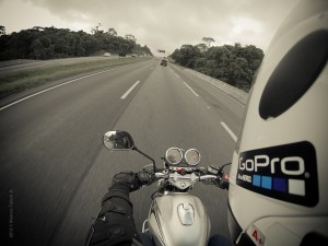 Photo taken by a GoPro camera mounted on the side a motorcyclists helmet as he drives down a highway.